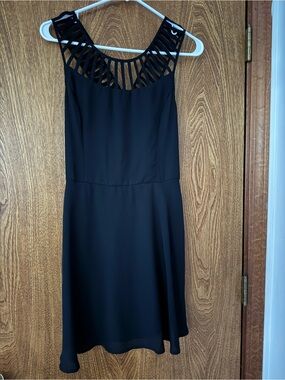 the clothing company Black Sleeveless Mini Dress with Laser-Cut Neckline